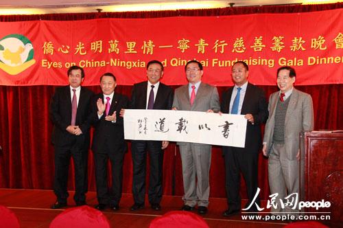 林军主席（左三）亲笔书写的“书以载道”的墨宝，一度掀起拍卖会的高潮。    人民网记者 马小龙 摄