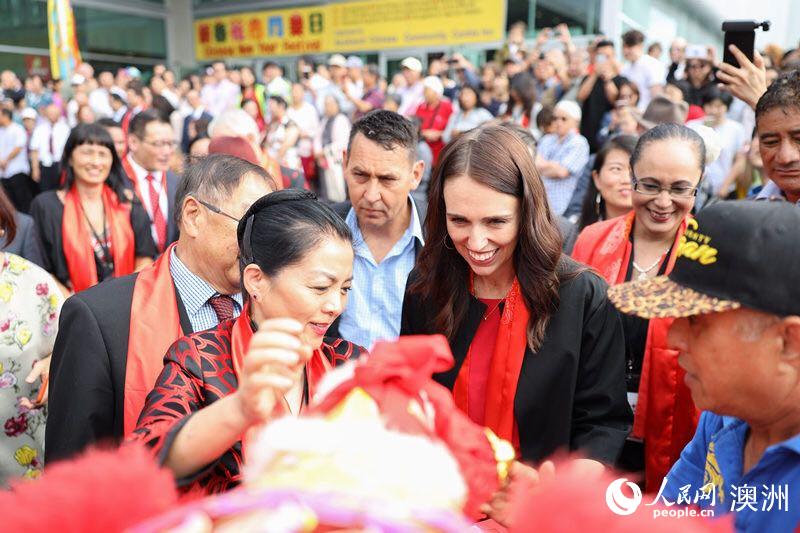 中國駐奧克蘭總領事許爾文與新西蘭總理杰辛達·阿德恩共同為花市舞獅團雄獅挂上節日繡球（攝影 張健勇）