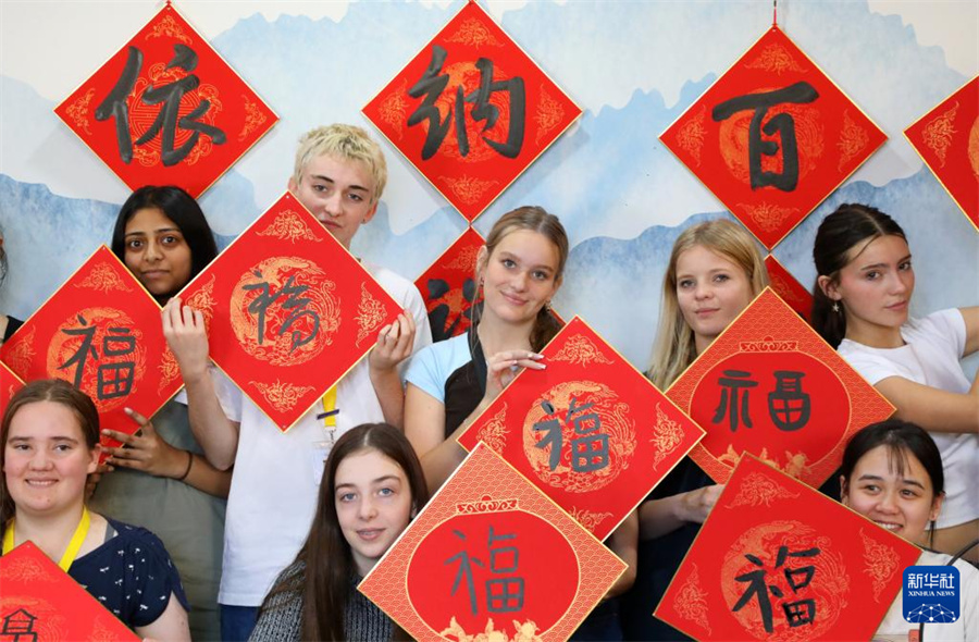 4月18日，惠靈頓東方女子中學的學生在北京師范大學實驗華夏女子中學體驗書法課，展示自己書寫的福字。新華社記者 侯俊 攝